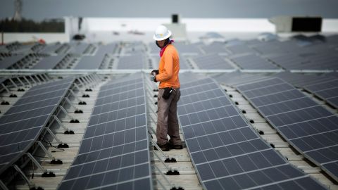 کارگری در سال 2014 در میان پانل‌های خورشیدی در حال نصب بر روی سقف یک IKEA در میامی قدم می‌زند. از فوریه، IKEA در 90 درصد مکان‌های خود در ایالات متحده، خورشیدی نصب کرده بود.